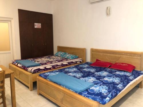 a bedroom with two beds and a table at Nhà Nghỉ Minh Thảo in Chơn Thành