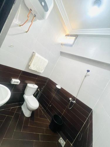 La salle de bains est pourvue de toilettes et d'un lavabo. dans l'établissement Louis Vuitton, à Abomey-Calavi