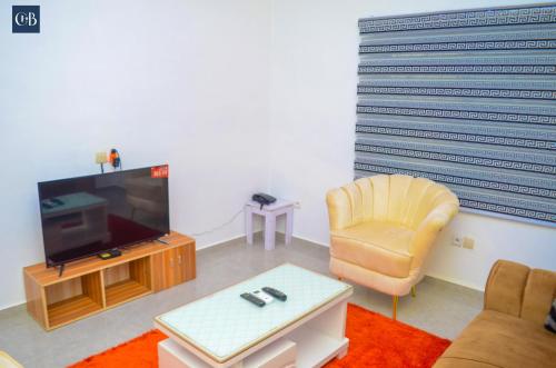 un salon avec une télévision et une chaise dans l'établissement Louis Vuitton, à Abomey-Calavi