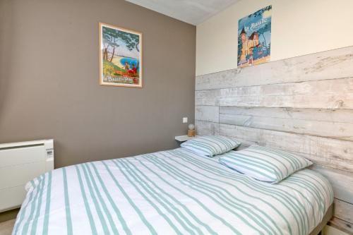 une chambre avec un lit avec une tête de lit en bois dans l'établissement Appartement vue mer - 50 m plage, à Pornichet
