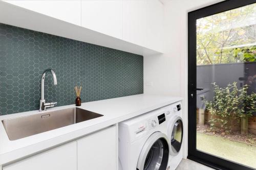 a kitchen with a sink and a washing machine at The Buller Retreat in New Plymouth