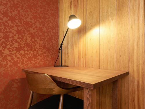 a desk with a lamp on a wooden wall at KONJAKUSO Nara Naramachi "MUSHIBUROYA" Sauna Villa in Nara