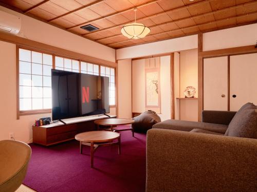a living room with a couch and a flat screen tv at KONJAKUSO Nara Naramachi "MUSHIBUROYA" Sauna Villa in Nara