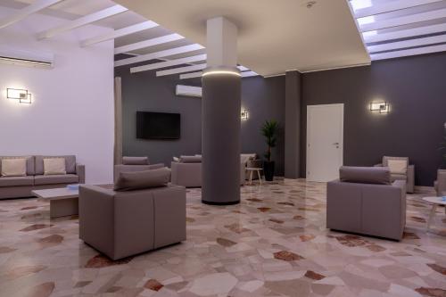 a lobby with couches and tables and a tv at Hotel Continental in Caorle