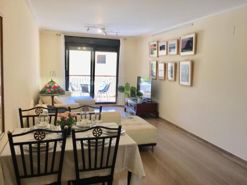 a dining room with a table and chairs and a television at Luxury spa living in Jávea