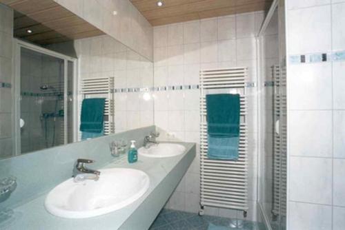 a white bathroom with two sinks and a shower at Appartements Platzis in Schruns-Tschagguns