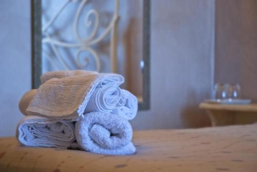 una pila de toallas sentadas encima de una cama en Portola la vecchia dimora, en Roncola