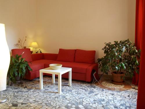 a living room with a red couch and a white table at Pisa Center in Pisa