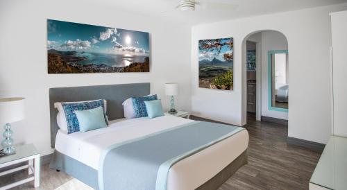 ein Schlafzimmer mit einem großen Bett und einem Gemälde an der Wand in der Unterkunft La Mariposa Mauritius in Rivière Noire