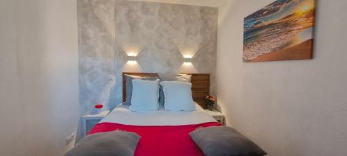 a bedroom with a bed with blue and white pillows at Charmant T2 climatisé avec belle vue , Golf de Pont-Royal in Mallemort