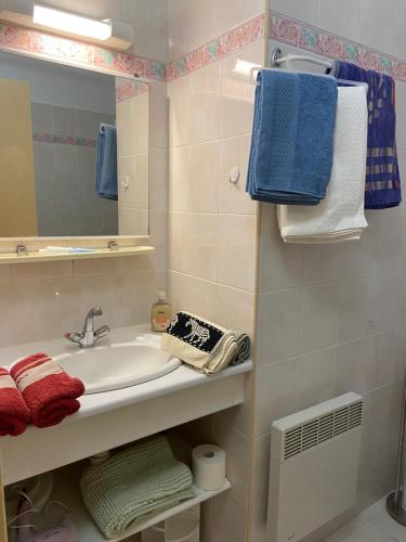 a bathroom with a sink and a mirror and towels at Maison Chevalier in Narbonne