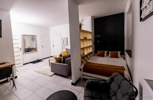 ein Schlafzimmer mit einem Bett und einem Stuhl in einem Zimmer in der Unterkunft KLIF 2 Warka in Warka
