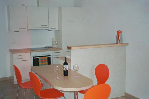 eine Küche mit einem Tisch und Stühlen mit Weingläsern in der Unterkunft Apartment Wieser in Minusio