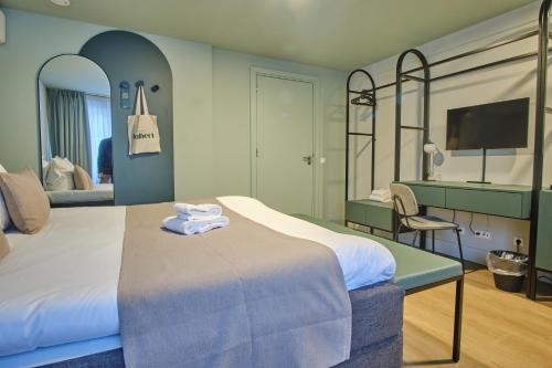 Habitación de hotel con cama y espejo en Hotel Halbert en Groningen