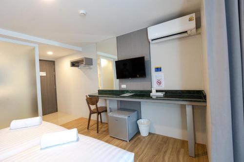 um quarto de hotel com uma secretária num quarto em วัน บัดเจท ตาก แม่สอด - One budget hotel Tak Maesot em Mae Sot