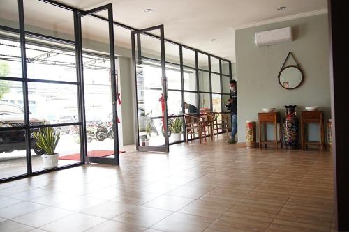 a man standing in a room with glass doors at Take Guesthouse 2 in Paalmerah