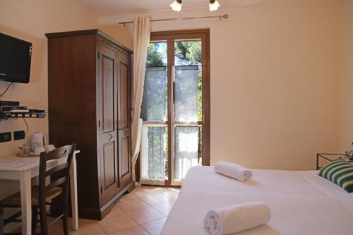 a bedroom with a bed and a desk and a window at Villa Gaia in Portoferraio