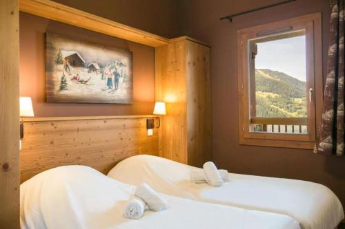 deux lits dans une chambre avec une fenêtre dans l'établissement Appartement Luxe Avec Vue : Au Pied des Pistes, à Sainte-Foy-Tarentaise