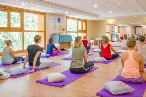 un groupe de personnes assises dans un cours de yoga dans l'établissement Appartement Luxe Avec Vue : Au Pied des Pistes, à Sainte-Foy-Tarentaise