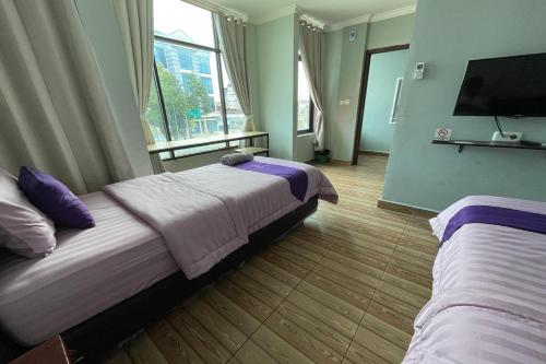 a bedroom with two beds and a flat screen tv at Take Guesthouse 2 in Paalmerah