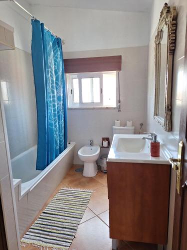 ein Badezimmer mit einer Badewanne, einem Waschbecken und einem WC in der Unterkunft Natural Mystic Hostel in Costa da Caparica