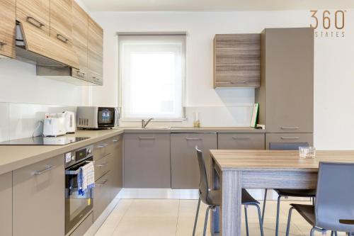 a kitchen with a wooden table and a wooden counter top at Lovely designer 3BR Apt with Private Terrace with BBQ by 360 Estates in Tal-Pietà