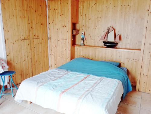 - une chambre avec un lit avec un bateau modèle sur le mur dans l'établissement Appartement de 2 chambres avec piscine partagee et wifi a La Jarrie, à La Jarrie
