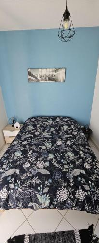 une chambre avec un lit avec une couverture noire et blanche dans l'établissement Appartement solaire duplex avec terrasse en bois, à Pessac