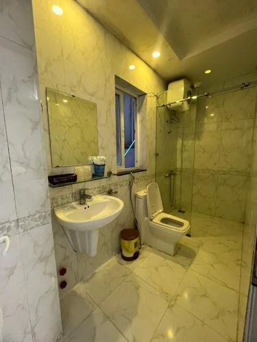 Un baño con lavabo, inodoro y ducha. en Minh Trang, en Da Lat