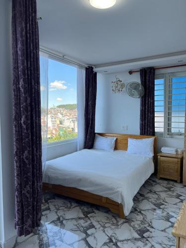 Un dormitorio con una cama y una ventana grande. en Minh Trang, en Da Lat