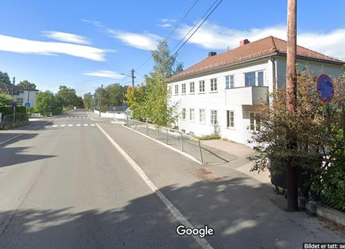 een lege straat met een wit gebouw en een huis bij Home Express Oslo in Oslo
