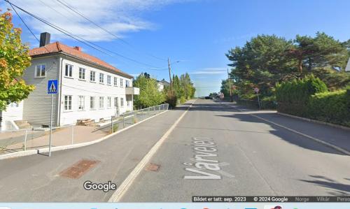 een lege straat in een stad met een wit gebouw bij Home Express Oslo in Oslo