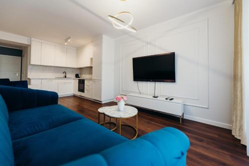 a living room with a blue couch and a tv at 3 Bedrooms Premium Bella Blue for 8 Guests with AC and Free out side Parking in Rzeszów
