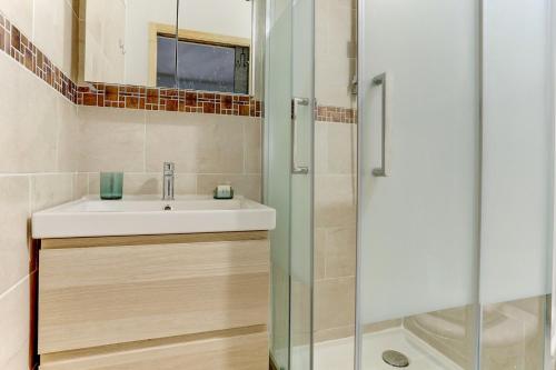 een badkamer met een wastafel en een douche bij Le Cozy - Saint Cyr in Saint-Cyr-lʼÉcole
