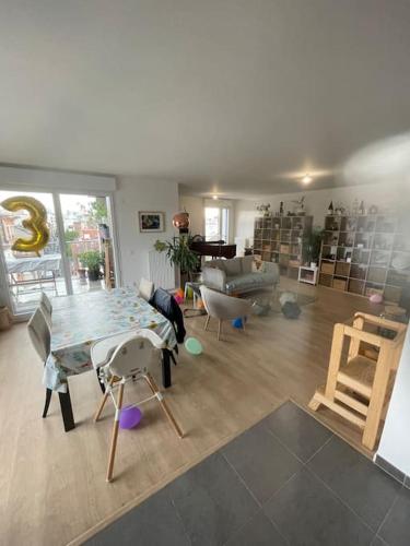 un salon avec une table et des chaises dans l'établissement Appartement très lumineux proche Métro Asnières, à Asnières-sur-Seine