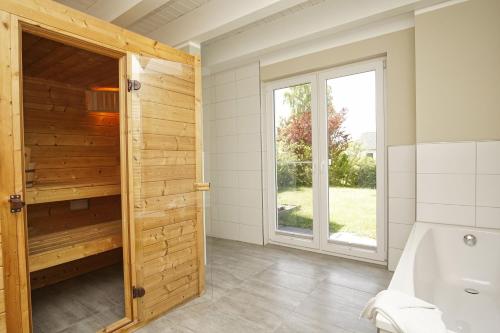 ein Bad mit einer Badewanne und einem Fenster in der Unterkunft Haus ButjeButje Haus - Terrasse, Sauna, Yachthafen in Gager