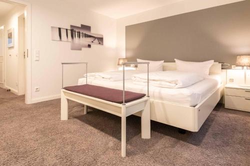 ein Schlafzimmer mit einem weißen Bett und einem Tablett darauf in der Unterkunft Haus Heide Hüs, App 2 in Wenningstedt-Braderup