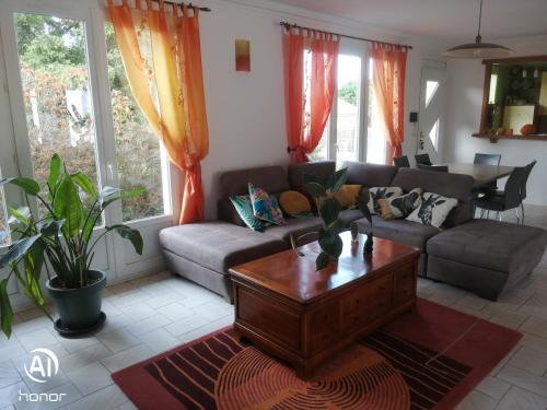 un salon avec un canapé et une table basse dans l'établissement chambres d hôtes Coco, à Arnage