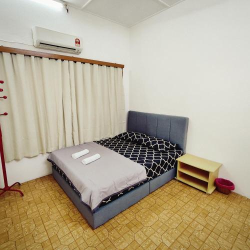 una piccola camera da letto con un letto e una finestra di Cheras Landed Homestay 4BR - 10Pax - MRT Suntex a Cheras
