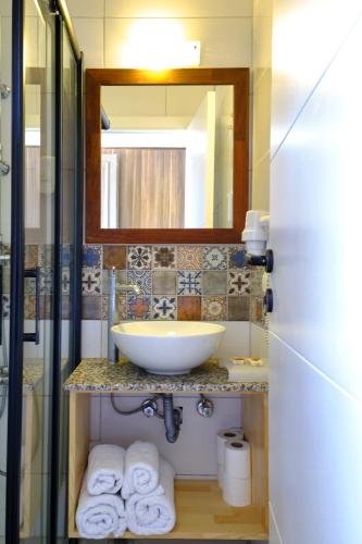 a bathroom with a sink and a mirror and towels at Aquarius Hotel in Kas