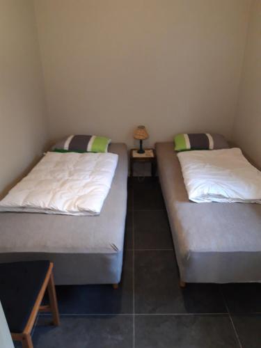 two twin beds in a small room with a table at - Schönes kleines Apartment zum Schlafen - in Moholm