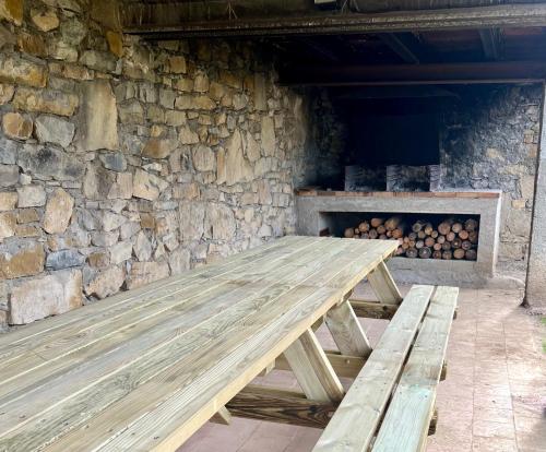 einer Holzbank vor einer Steinmauer in der Unterkunft Can Sau in Sant Joan de les Abadesses