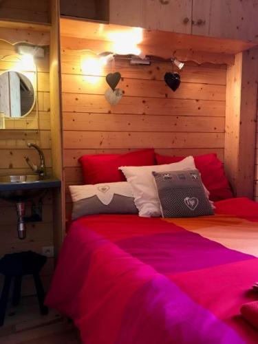 a bedroom with a large bed with red sheets at Studio Tiny en duplex - face télécabines in Ax-les-Thermes