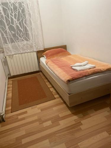 a bedroom with a bed with a wooden floor at Sobe Braica in Drniš