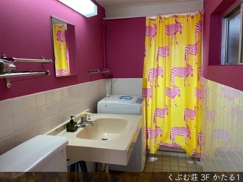 a bathroom with a sink and a shower curtain at くぶむ荘 in Shimoyatori