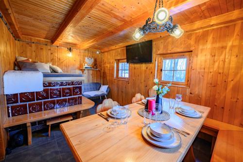 ein Esszimmer mit einem Tisch und ein Schlafzimmer in der Unterkunft Relax house AVUS with Sauna in Slap ob Idrijci