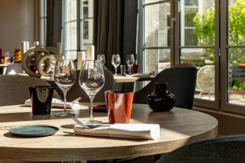 a wooden table with wine glasses on it at Mercure Angoulême Hôtel de France in Angoulême