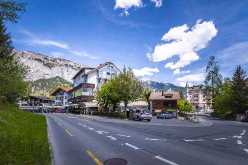 a street in a town with houses and a mountain at VISIMO Apartments Flims with private Sauna in Flims