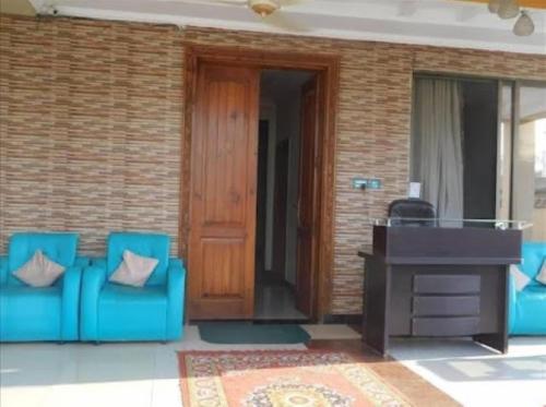 a pair of blue chairs in front of a desk at Deen Resort Motel in Mānsehra