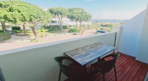 a table and chairs on a balcony with a view at Studio climatisé 1 à 4 personnes vue mer in Le Grau-du-Roi
